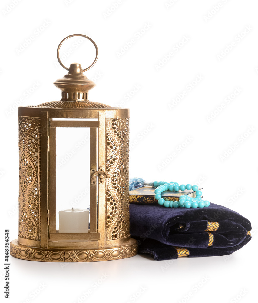 Muslim lantern with prayer rug, tasbih and Quran on white background