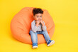 © deagreez - Full length body size photo little boy sitting in beanbag wearing casual clothes isolated bright yellow color background