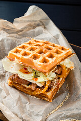 Poster - Waffle sandwich with meat and vegetables on wooden table background