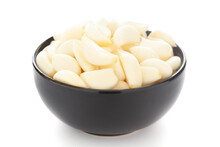 Close-Up Of Organic Fresh Peeled Garlic (Allium Sativum) In Black Ceramic Bowl Over White Background