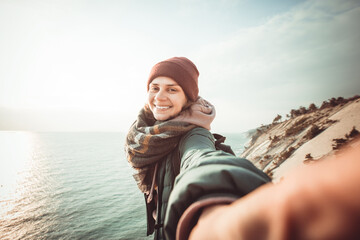 happy woman traveler makes selfie on the background of the sea and sky. she is inspired and free. th