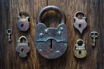 Fototapete - Collection of antique door locks and keys on an old board. Vintage padlock and key. set as a symbol of security, closeness, security, etc. Conceptual background.
