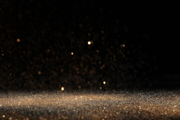 Wall Mural - shiny golden glitter falling down on black background. bokeh effect