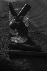 bamboo charcoal sticks in glass with water on coal powder black background..powerful water purifier