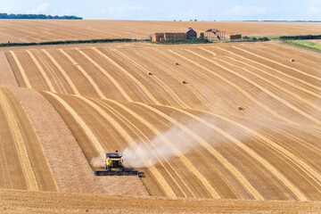 Crop havesting on a dry sunny day with farm buildings