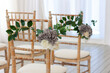 The wooden chair is decorated with flowers in honor of the wedding.