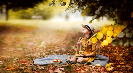 Autumn picnic, child girl in dress and hat on a picnic among autumn foliage, banner and copy space