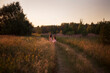 © leonidis97 - Two sisters run barefoot along the road holding hands.