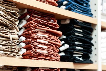 Close up of Colorful stack of jeans in a clothes shop with EAS anti theft sensor stick to it