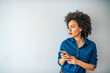© Dragana Gordic - Beautiful smiling curly-haired businesswoman using smarphone. Content trendy cheerful nice cute adorable lovely girl with wavy hair in casual denim shirt, typing in phone