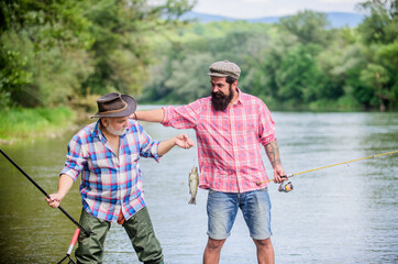 Wall Mural - Getting You in Motion. Fly Fishing Time. hobby. Big game fishing. friendship. Camping on the shore of lake. two happy fisherman with fishing rod and net. hunting tourism. father and son fishing