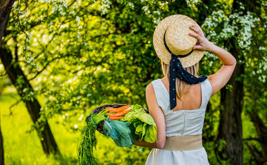 young woman with vegetable basket in a garden