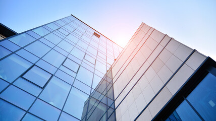 Futuristic facade of a modern office building clad in glass. Glass cladding panels and windows of modern building. An office building with geometry and perspective.