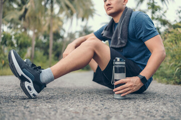 Wall Mural - water bottle on the ground side.sport man sitting after running. Sport thirsty and resting after exercise.