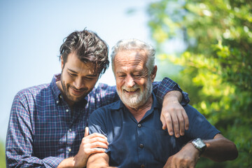 caucasian senior father and adult son are hugging together at home, generation family are happy with