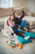 © Strelciuc - Caucasian lovely couple are sitting on the floor covered with a plaid eating cereals with milk