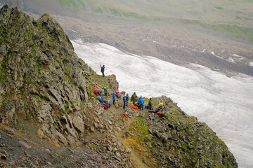 A group of tourists is standing on the mountain. Climbing Kazbek from the north, from the side of Russia.