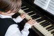 Portrait of kid playing piano, Young boy learning music with an piano in musical scholl. Child relaxing playing piano