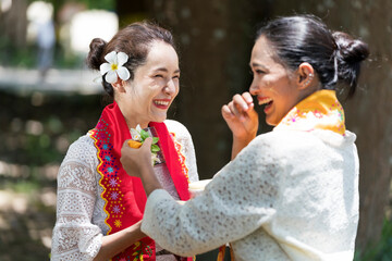 Burmese women are laughing and having fun. Southeast Asian young girls with burmese traditional dress visiting a Buddihist temple.