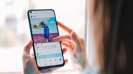 The Girl is holding a smartphone and using a Blogging app 