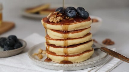 Wall Mural - Stack of pancakes with berries, walnuts and maple syrup. Syrup pouring