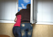 Two lovers look out the window hugging each other