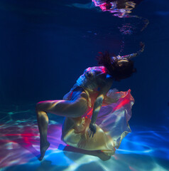 beautiful girl under the water in a beige dress