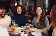 © Southworks - Friends laughing in restaurant