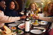 © Southworks - Friends toasting wine glasses at dinner