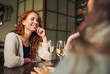 © Southworks - Young woman relaxing with friends in bar