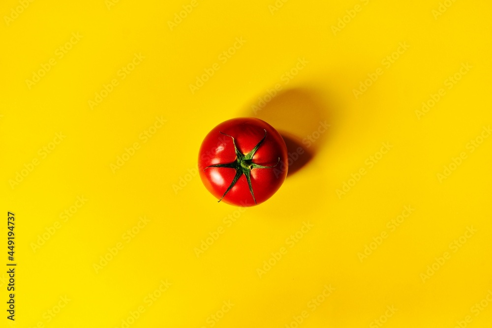red tomato on a yellow background - obrazy, fototapety, plakaty 