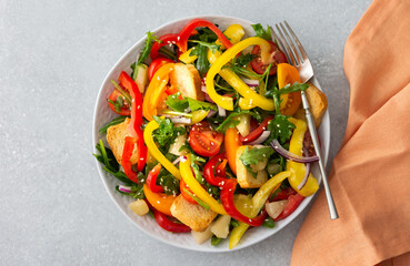 Light summer fresh salad with colorful tomatoes and croutons, sweet peppers and pineapple with sesame seeds, top view