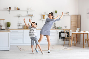 Sticker - Young woman and her little son dancing in kitchen