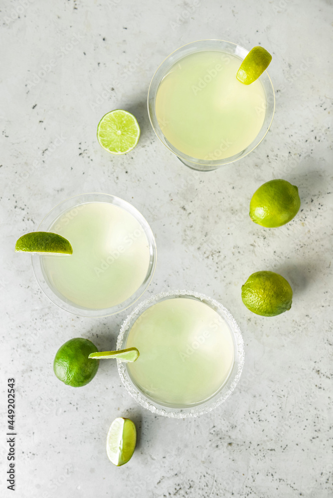 Glasses with tasty daiquiri cocktail on light background