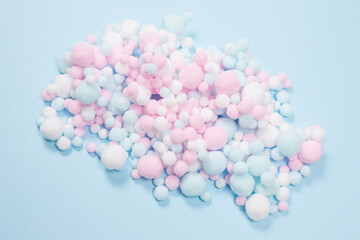 White, pink and blue soft pompons as a background.