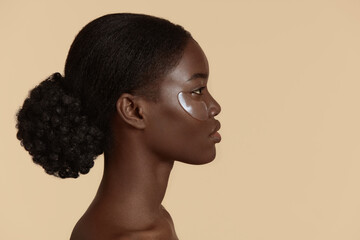 close up of beautiful african girl with under eye patch on face. profile of serious young woman with