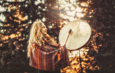 Poster - beautiful shamanic girl playing on shaman frame drum in the nature.