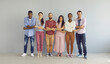 © Studio Romantic - Portrait of a smiling group of diverse multiracial people standing in a row holding hands. Best friends demonstrate their unity. Concept of friendship between different races and nationalities.