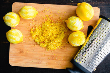 Wall Mural - Lemon Zest on a Bamboo Cutting Board: Zested lemons and a box grater on a wood cutting board