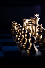 Poster - Vertical shot of golden chess pieces on a chessboard