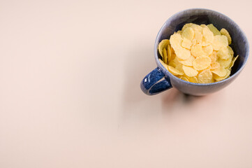 Sticker - Top view of corn flakes on a cup isolated on light brown background