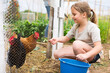 © JackF - Smiling little girl feeding poultry in aviary at allotment while her family gardening