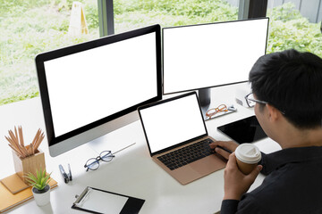 Businessman drinking coffee and working with multiple modern devices.