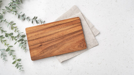 Wall Mural - Wood cutting board with linen napkin and plant on marble table