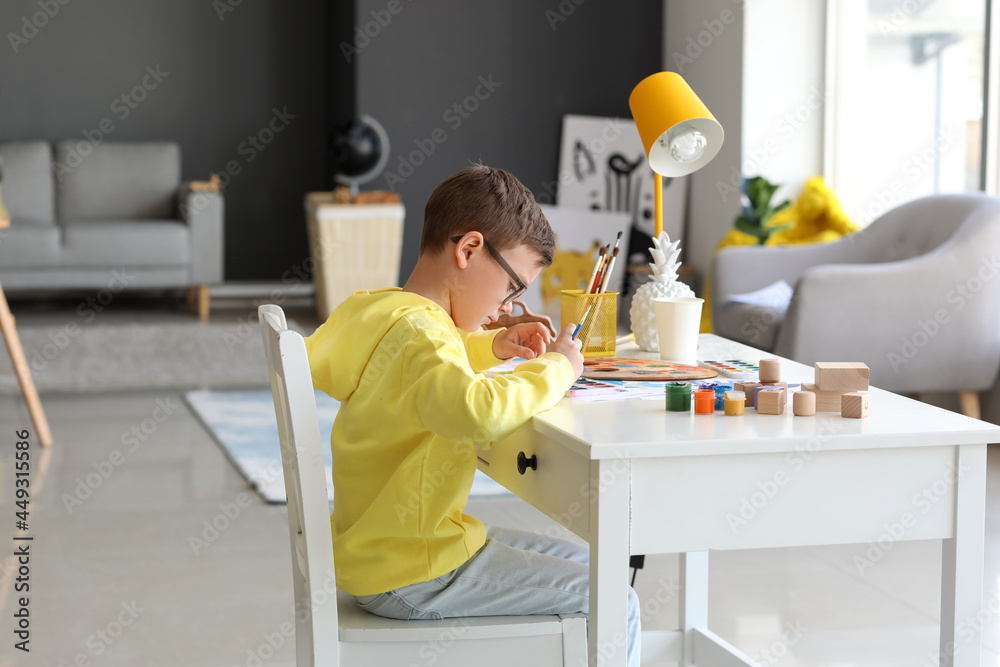 Cute little boy painting at home