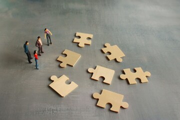 Business teamwork with scramble puzzle cooperation unity support concept. Miniature people look at the scramble puzzle.