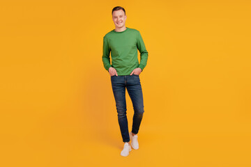 Wall Mural - Portrait of confident guy hands pockets toothy white smile posing on yellow background