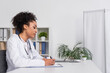 © LIGHTFIELD STUDIOS - Side view of african american doctor writing on clipboard in clinic