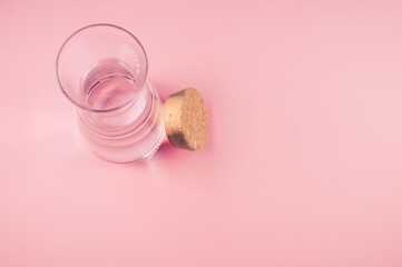 Poster - Top view of a clear glass bottle with cork stopper isolated on a pink  background