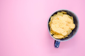 Sticker - Top view of corn flakes on a cup isolated on light pink background